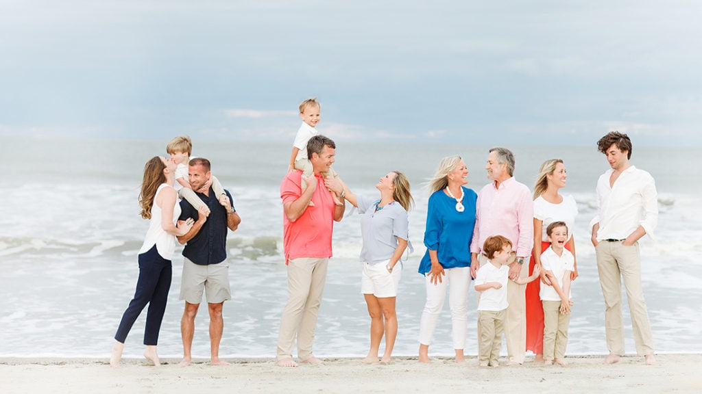 tybee family photographers. extended family on tybee island beach hugging for portrait